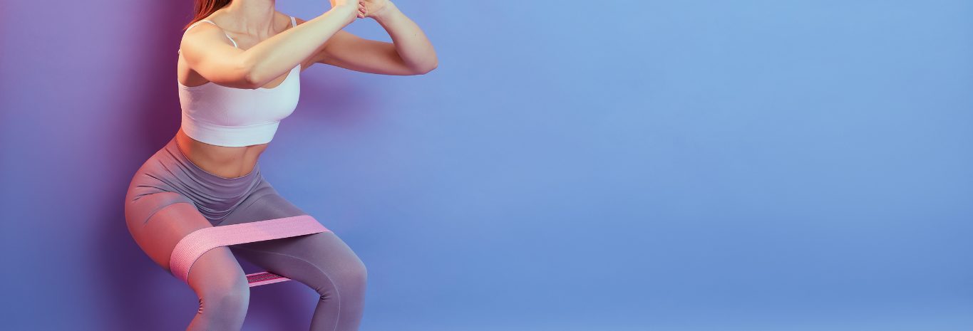 Mujer trabajando piernas y glúteo con banda elástica